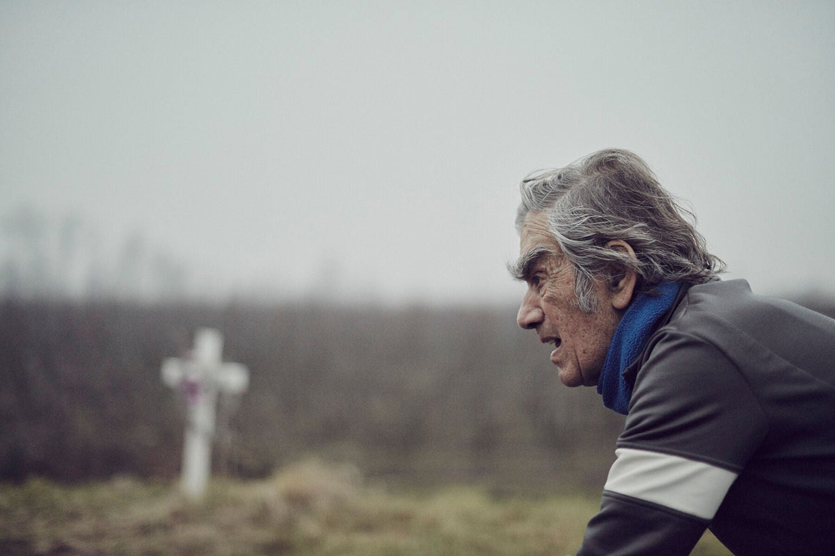 Nederlandse Wielerfotografie 'A Cross to Bare' - Albert, een 82-jarige wielrenner, op zijn op maat gebouwde stalen fiets langs de Waal- en Lekdijken, Nederland, fine art print door Cyclingprints.nl