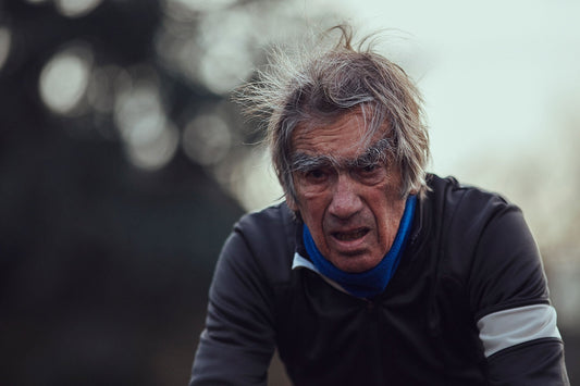 Nederlandse Wielerfotografie 'Against the Wind' - Albert, een 82-jarige wielrenner, op zijn op maat gebouwde stalen fiets langs de Waal- en Lekdijken, Nederland, fine art print door Cyclingprints.nl