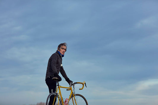 Nederlandse Wielerfotografie 'Blue Skies' - Albert, een 82-jarige wielrenner, op zijn op maat gebouwde stalen fiets langs de Waal- en Lekdijken, Nederland, fine art print door Cyclingprints.nl