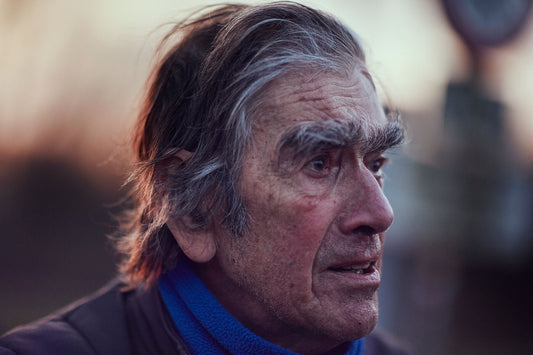 Nederlandse Wielerfotografie 'Brow Beaten' - Albert, een 82-jarige wielrenner, op zijn op maat gebouwde stalen fiets langs de Waal- en Lekdijken, Nederland, fine art print door Cyclingprints.nl