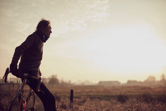 Nederlandse Wielerfotografie 'Golden Hour' - Albert, een 82-jarige wielrenner, op zijn op maat gebouwde stalen fiets langs de Waal- en Lekdijken, Nederland, fine art print door Cyclingprints.nl