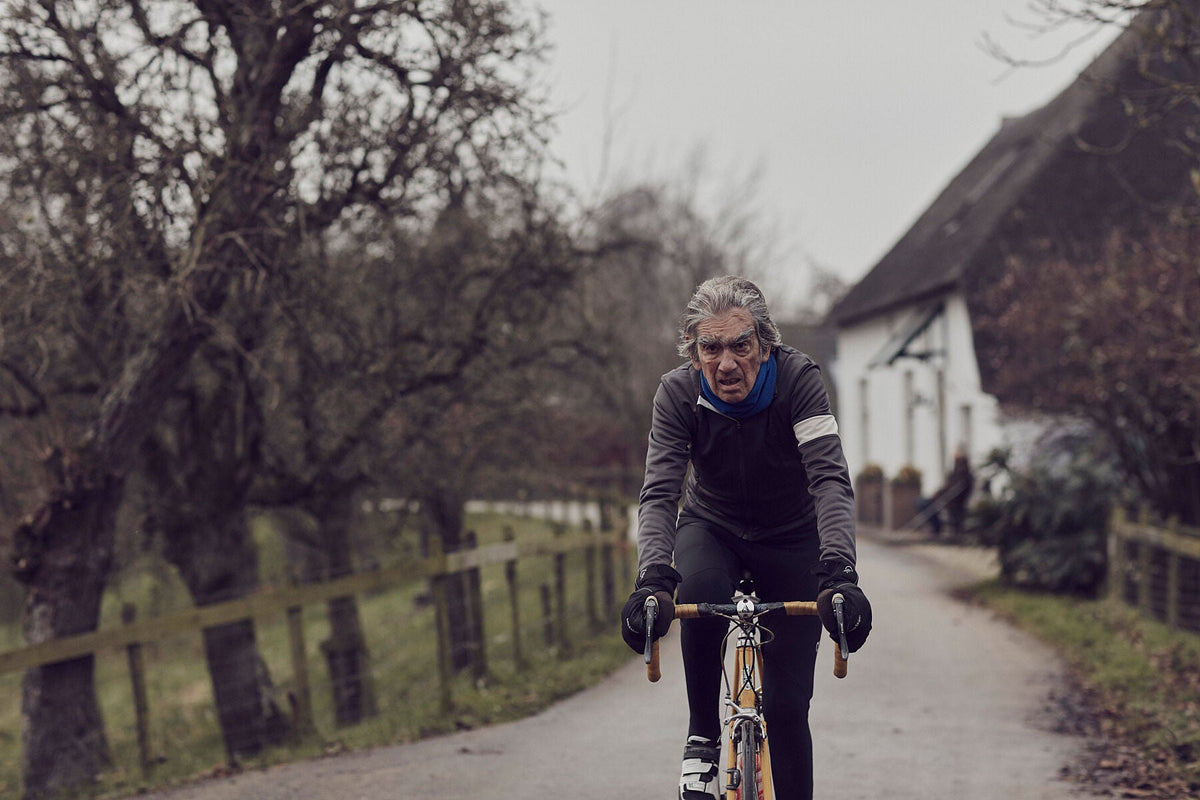 Nederlandse Wielerfotografie 'Leaden Skies' - Albert, een 82-jarige wielrenner, op zijn op maat gebouwde stalen fiets langs de Waal- en Lekdijken, Nederland, fine art print door Cyclingprints.nl