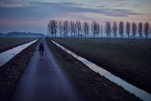 Nederlandse Wielerfotografie 'Purple Polders' - Albert, een 82-jarige wielrenner, op zijn op maat gebouwde stalen fiets langs de Waal- en Lekdijken, Nederland, fine art print door Cyclingprints.nl
