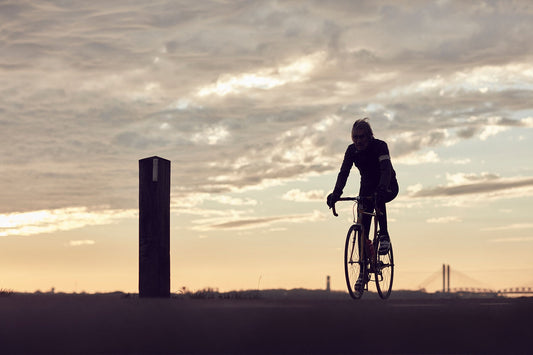 Nederlandse Wielerfotografie 'Sunsets & Spokes' - Albert, een 82-jarige wielrenner, op zijn op maat gebouwde stalen fiets langs de Waal- en Lekdijken, Nederland, fine art print door Cyclingprints.nl