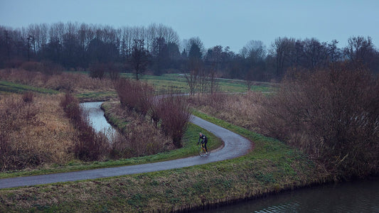 Nederlandse Wielerfotografie 'Twists & Turns' - Albert, een 82-jarige wielrenner, op zijn op maat gebouwde stalen fiets langs de Waal- en Lekdijken, Nederland, fine art print door Cyclingprints.nl