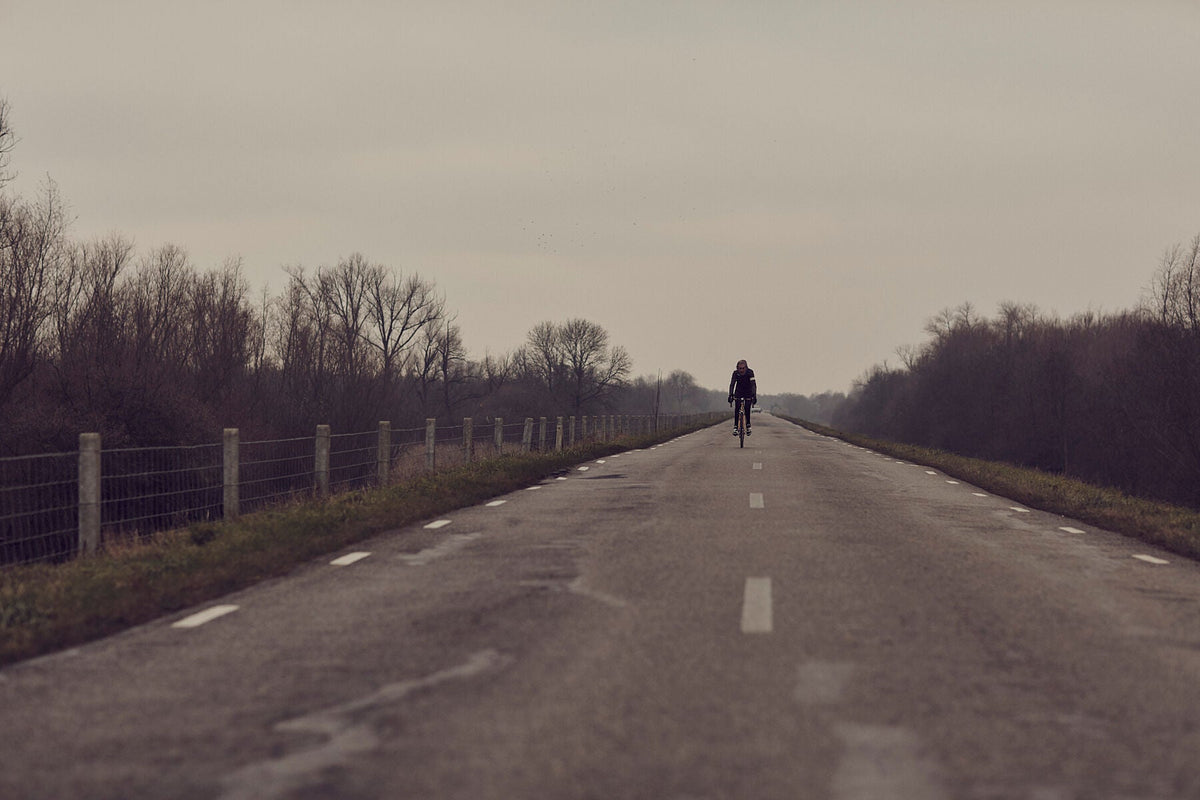 Nederlandse Wielerfotografie 'Winter Rides' - Albert, een 82-jarige wielrenner, op zijn op maat gebouwde stalen fiets langs de Waal- en Lekdijken, Nederland, fine art print door Cyclingprints.nl