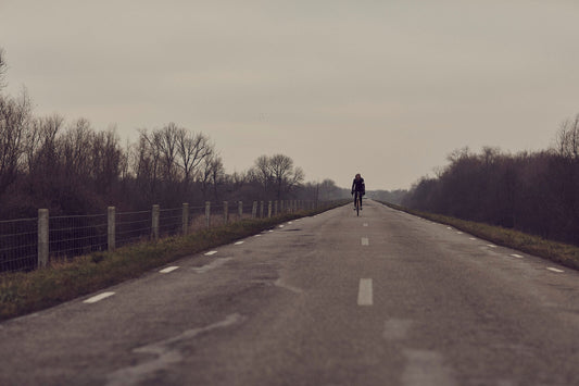 Nederlandse Wielerfotografie 'Winter Rides' - Albert, een 82-jarige wielrenner, op zijn op maat gebouwde stalen fiets langs de Waal- en Lekdijken, Nederland, fine art print door Cyclingprints.nl