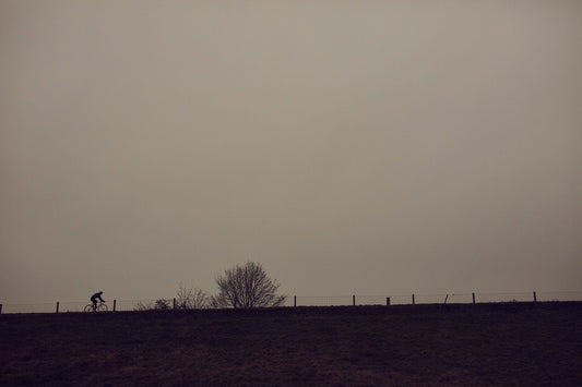 Nederlandse Wielerfotografie 'Wintry Dikes' - Albert, een 82-jarige wielrenner, op zijn op maat gebouwde stalen fiets langs de Waal- en Lekdijken, Nederland, fine art print door Cyclingprints.nl