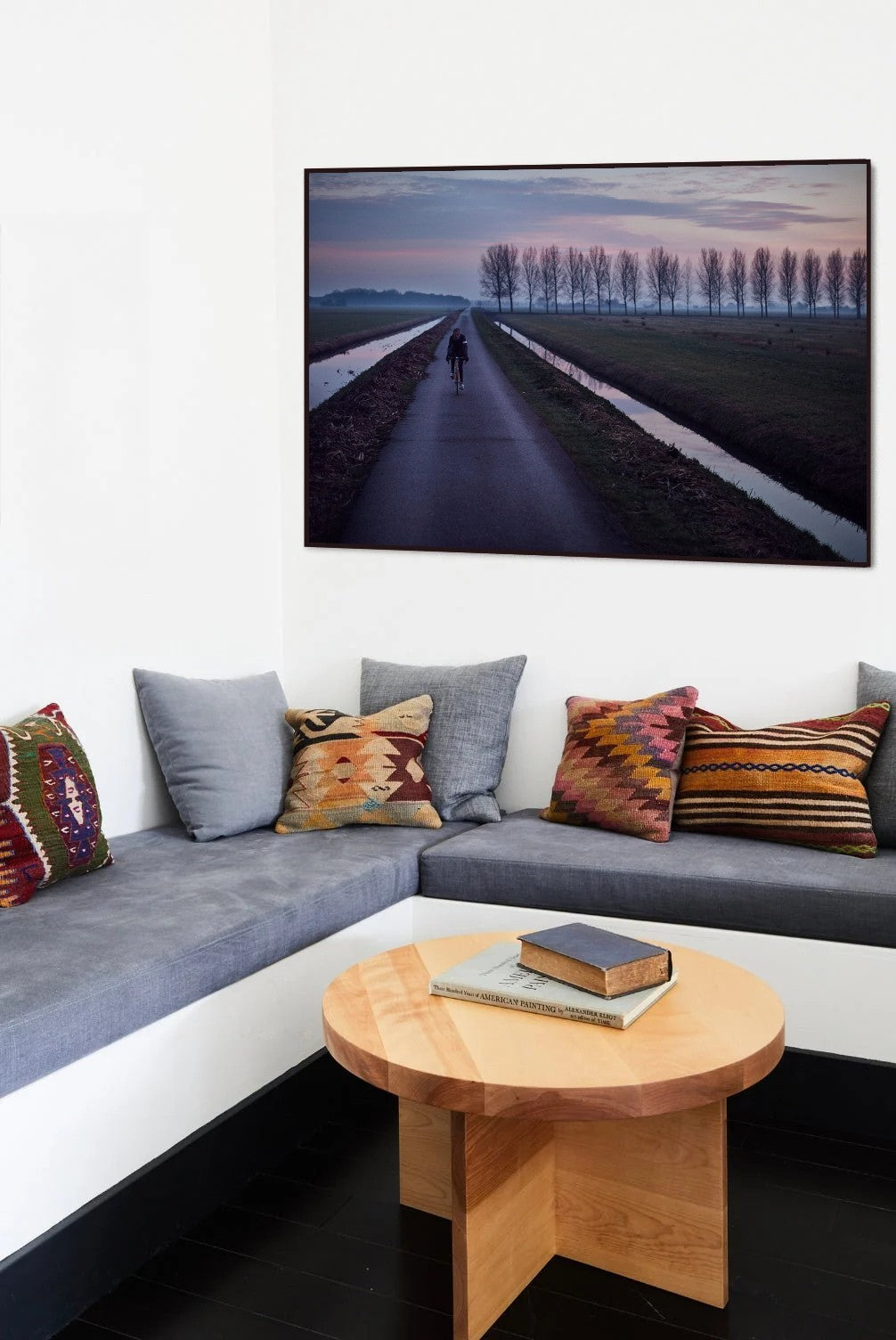 Purple Polders 2 Man of Steel cycling print in a black frame on a living room wall